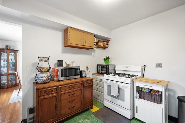 kitchen with gas range gas stove and dark hardwood / wood-style flooring