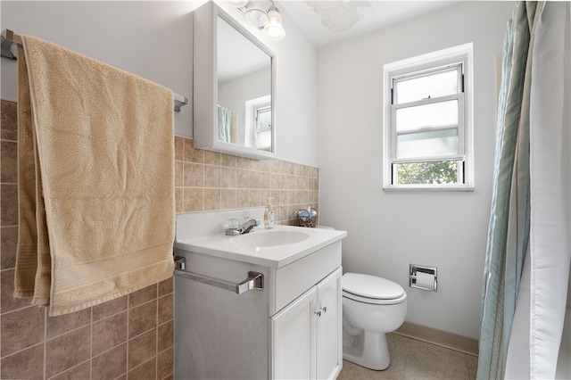 bathroom with toilet, vanity, and tile walls