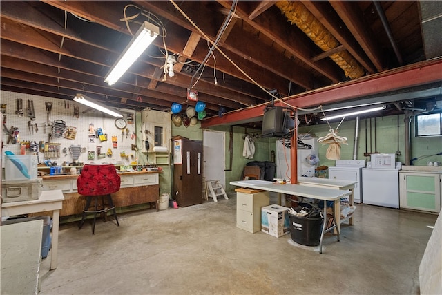 basement with washer and dryer and a workshop area