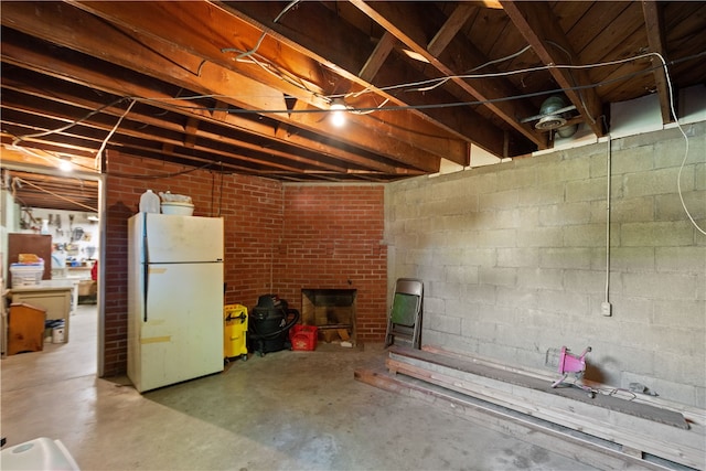 basement featuring white fridge and a fireplace