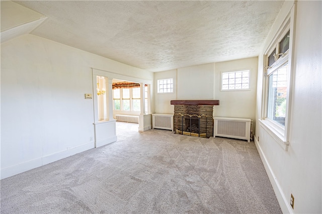 unfurnished living room featuring a textured ceiling, radiator, and plenty of natural light