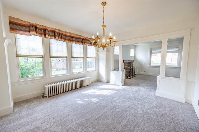 unfurnished dining area featuring radiator, light carpet, a wealth of natural light, and ornate columns