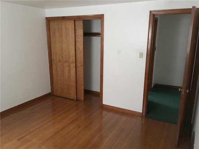 unfurnished bedroom featuring hardwood / wood-style flooring and a closet