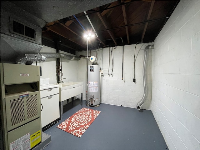 basement featuring water heater, sink, and heating unit