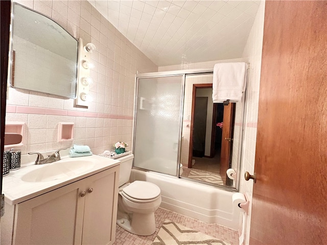 full bathroom featuring enclosed tub / shower combo, vanity, toilet, tile walls, and tile patterned flooring