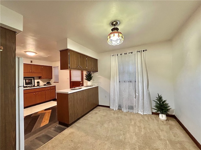 kitchen featuring hanging light fixtures, kitchen peninsula, and light carpet