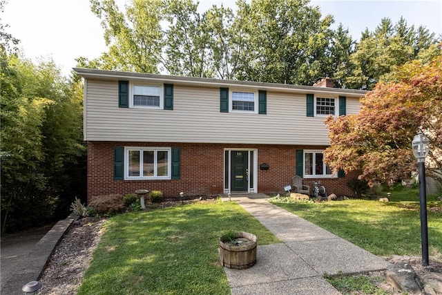 colonial inspired home featuring brick siding and a front lawn