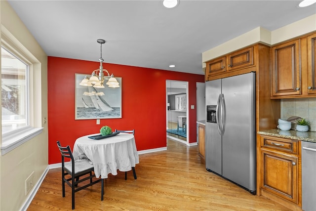 kitchen featuring light hardwood / wood-style floors, stainless steel appliances, decorative light fixtures, and a chandelier