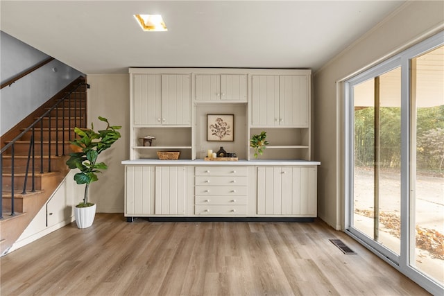 kitchen with white cabinetry, light hardwood / wood-style flooring, and a healthy amount of sunlight