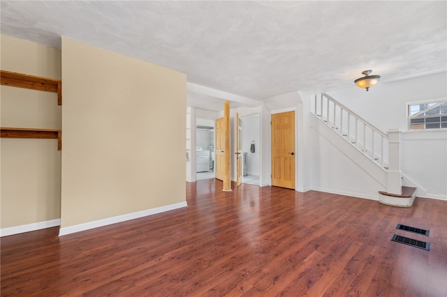 unfurnished living room with washer / dryer, dark hardwood / wood-style flooring, and a textured ceiling