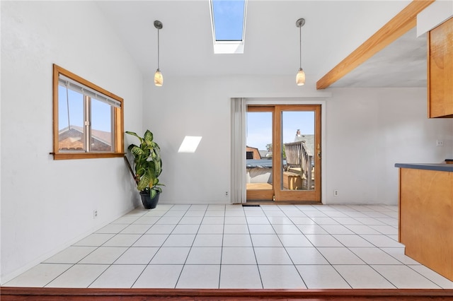 spare room featuring light tile patterned floors and lofted ceiling with skylight