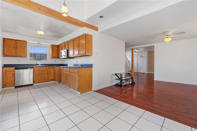 kitchen with light wood-type flooring, decorative light fixtures, stainless steel appliances, sink, and ceiling fan