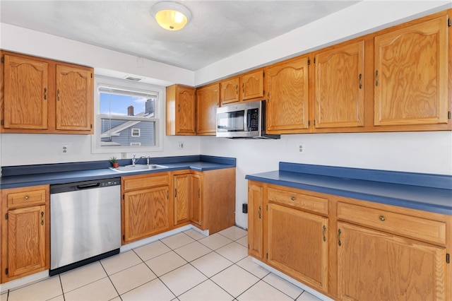 kitchen featuring light tile patterned floors, stainless steel appliances, and sink