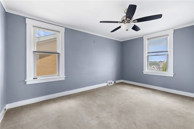 carpeted empty room with ceiling fan and ornamental molding