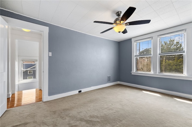 carpeted spare room featuring ceiling fan