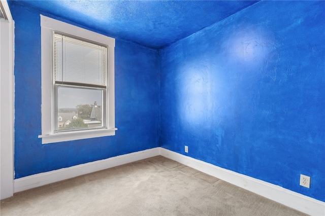 spare room featuring a textured ceiling and carpet floors