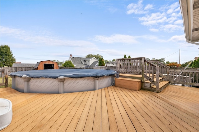 deck featuring a covered pool and a storage unit