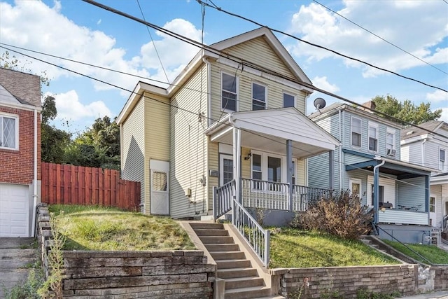 traditional home with a porch, stairway, and fence