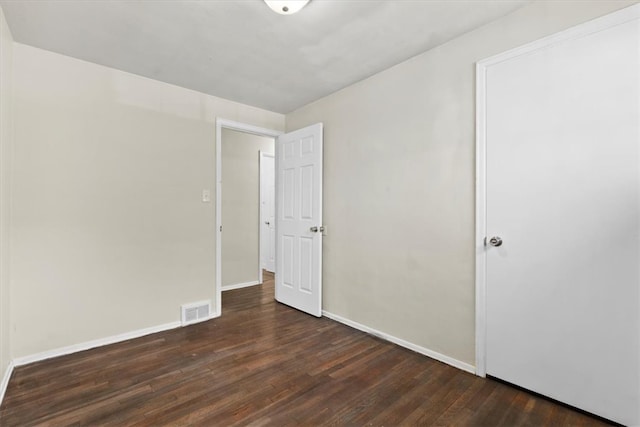 empty room with dark hardwood / wood-style flooring