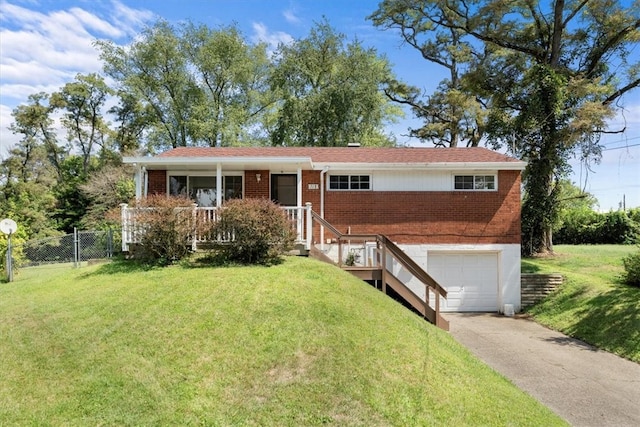 view of front of home with a front yard, a garage, and a porch