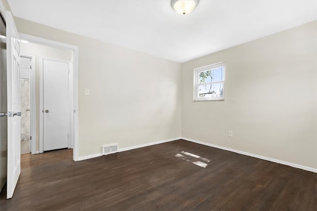 unfurnished room with dark hardwood / wood-style flooring