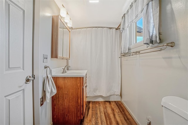 bathroom with hardwood / wood-style floors, toilet, and vanity