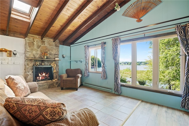 living room featuring a wealth of natural light, baseboard heating, a stone fireplace, and a skylight