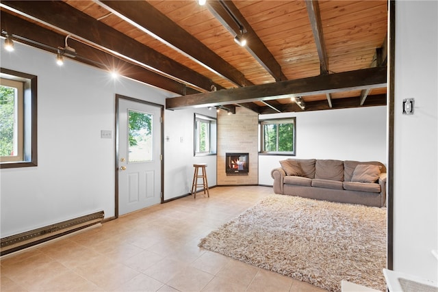 tiled living room with a large fireplace, baseboard heating, plenty of natural light, and beamed ceiling