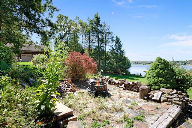 view of yard with a fire pit and a water view