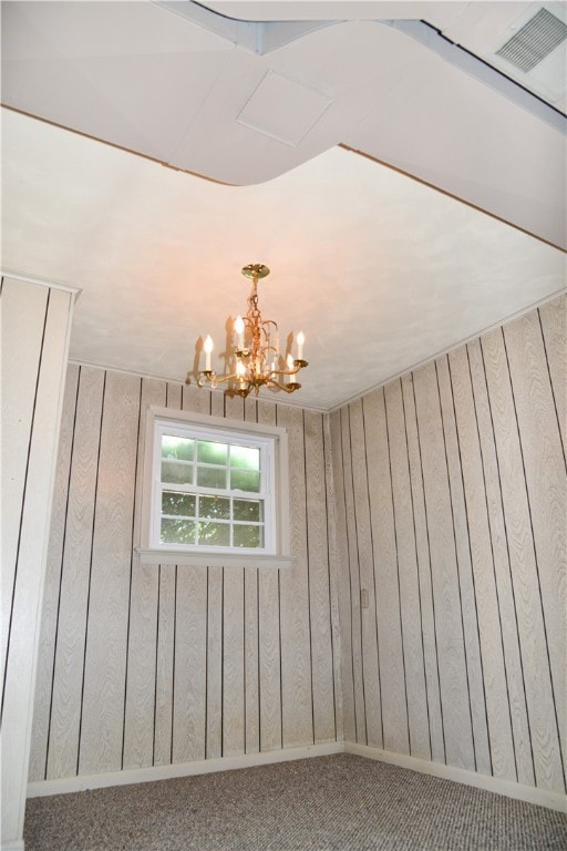 details featuring wood walls and an inviting chandelier