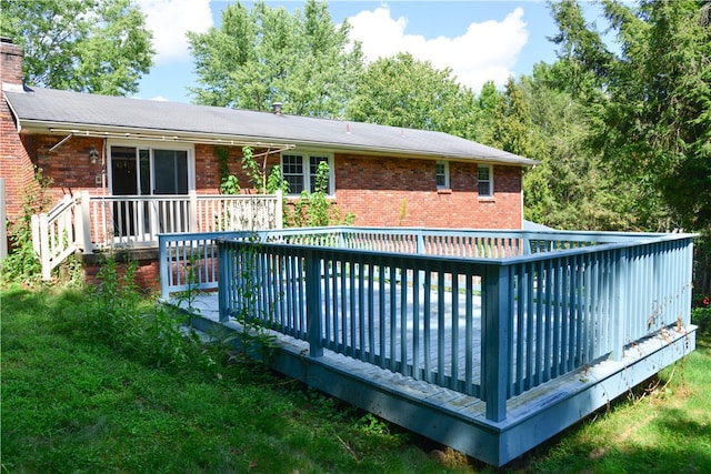 rear view of house with a lawn and a deck