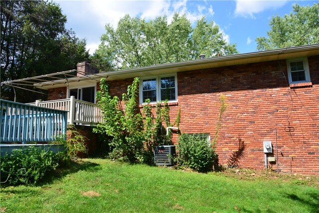 rear view of house featuring a yard and central air condition unit