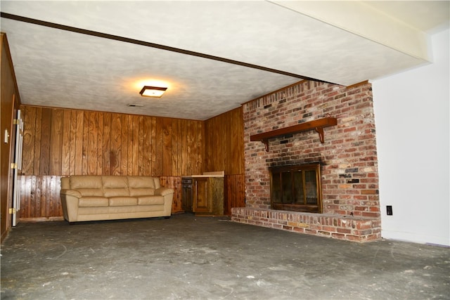 unfurnished living room with wood walls and a fireplace