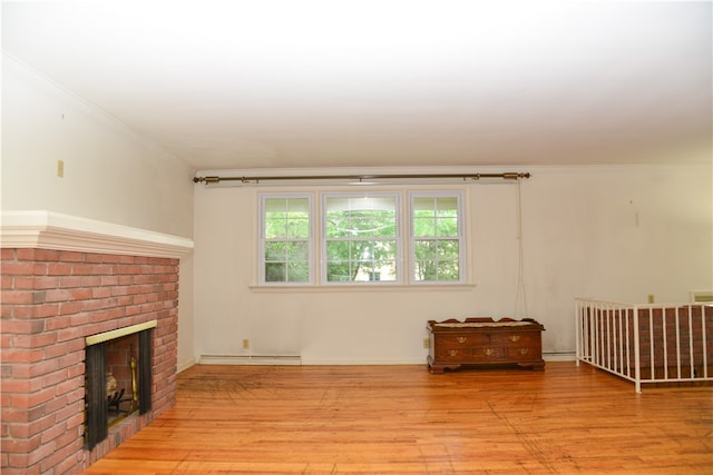 living room with a fireplace, crown molding, light hardwood / wood-style floors, and a baseboard heating unit