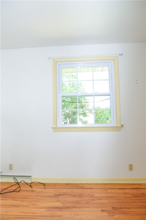 spare room featuring light wood-type flooring and baseboard heating