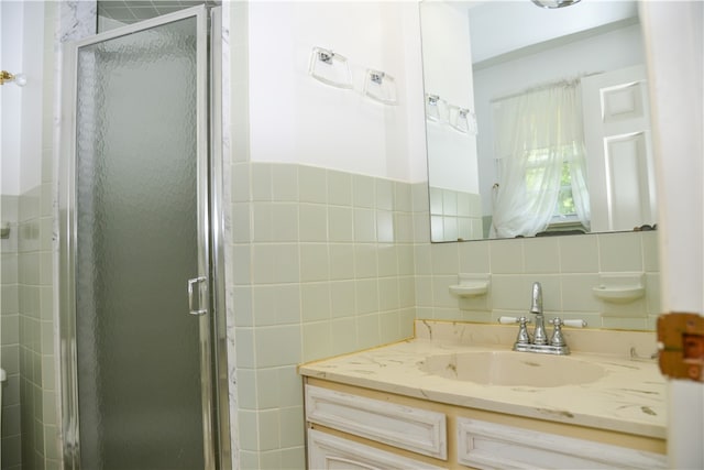 bathroom with tile walls, walk in shower, vanity, and tasteful backsplash