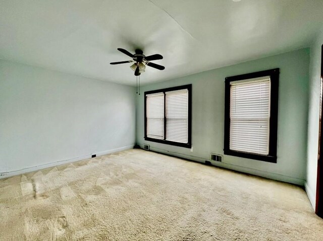 unfurnished room featuring ceiling fan and carpet