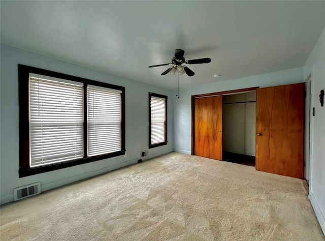 unfurnished bedroom with multiple windows, a closet, ceiling fan, and carpet floors