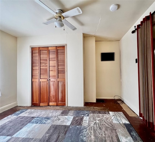 unfurnished bedroom featuring ceiling fan, dark hardwood / wood-style floors, and a closet