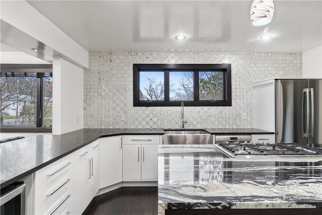 kitchen featuring white cabinets, backsplash, and a healthy amount of sunlight