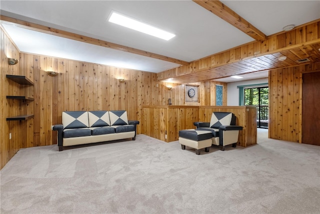 living area with carpet flooring, wooden walls, and beamed ceiling