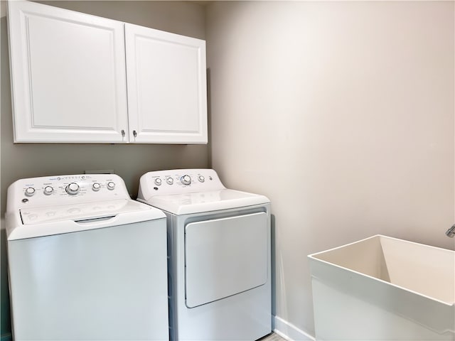 laundry room featuring cabinets, washing machine and dryer, and sink