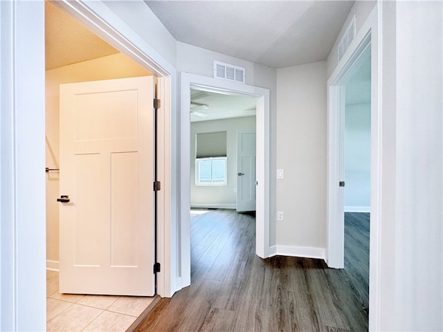 corridor with light hardwood / wood-style floors