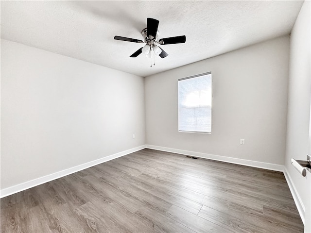 spare room featuring hardwood / wood-style floors, ceiling fan, and a textured ceiling