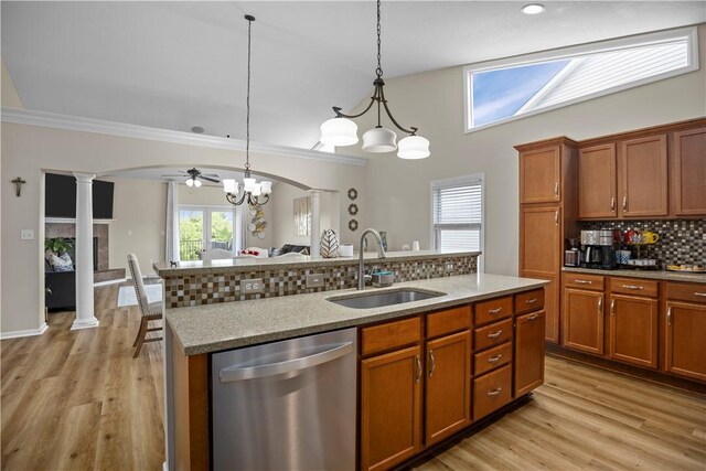 kitchen with backsplash, sink, ornate columns, stainless steel dishwasher, and light hardwood / wood-style floors