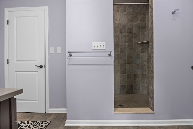 bathroom with tile patterned floors, tiled shower, and vanity