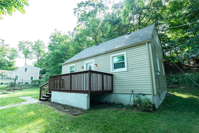 rear view of house with a yard and a deck