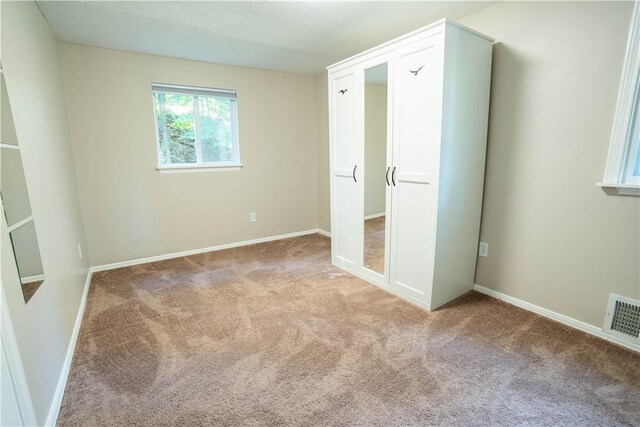 unfurnished bedroom with light colored carpet