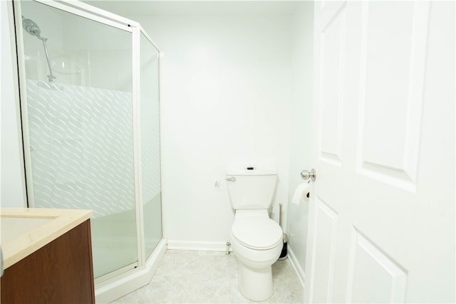 bathroom featuring tile patterned flooring, vanity, toilet, and walk in shower