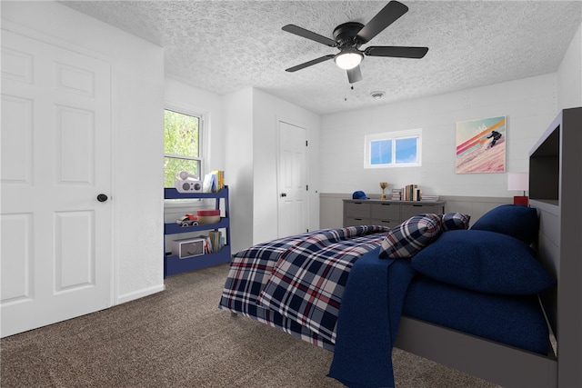 bedroom featuring ceiling fan, carpet flooring, and a textured ceiling